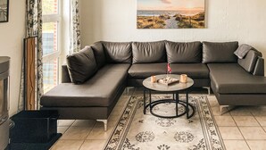 A living room with a sectional sofa, a coffee table, and a rug.