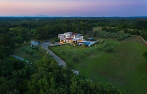A large, modern house with multiple levels and a spacious backyard.