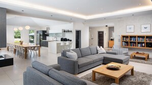 A modern living room with a grey sectional sofa, a wooden coffee table, and a bookshelf filled with books. - Luxurious home in Svetvincenat (Svetvincenat)