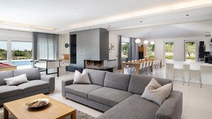 A modern living room with grey sofas, a wooden coffee table, and a fireplace. - Luxurious home in Svetvincenat (Svetvincenat)