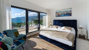 Une chambre à coucher avec un grand lit, une chaise, une table de chevet et un tableau.