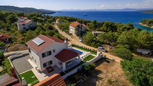 A coastal residential area with houses, a swimming pool, and a view of the sea. - Beautiful home in Makarac (Makarac)