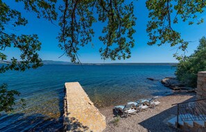 Enjoy serene lakeside views from a tranquil seating area with lounge chairs.
