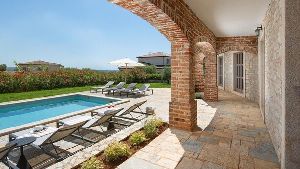 A pool area with lounge chairs and a clear view of the sea. - Amazing home in Sv. Lovrec (Sv. Lovrec)