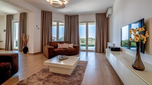 Una sala de estar moderna con un sofá, una mesa de centro y un televisor de pantalla plana.