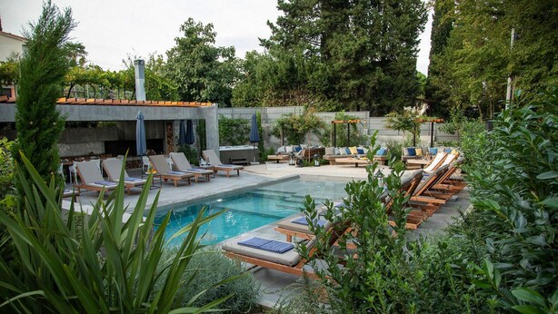 Un espace aménagé au bord de la piscine, avec des chaises longues et un barbecue.
