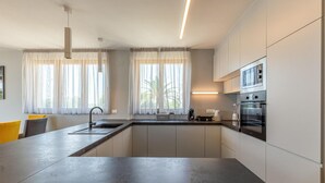Una cocina moderna con una isla central, electrodomésticos de acero inoxidable y un ambiente luminoso y espacioso.