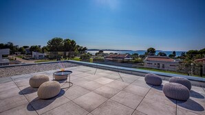 Terraza en la azotea con mobiliario exterior y vistas al mar.