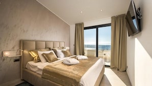 A modern hotel room with a large bed, a flat-screen TV mounted on the wall, and a balcony with a view. - Pet friendly home in Smrika with WiFi (Smrika)