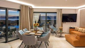 A modern living room with a dining area, large windows, and a view of the outdoors. - Pet friendly home in Smrika with WiFi (Smrika)