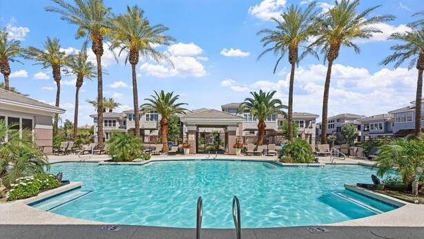A swimming pool surrounded by palm trees and lounge chairs, with a clear blue sky in the background. - Peaceful Kierland 2BR Condo | Pool, Spa | Free Parking | Golf Access | Gym Walk to Shops & Dining (Scottsdale)