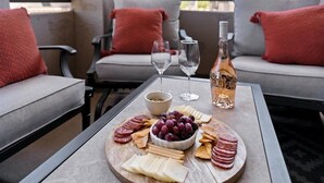 A terrace with a table set for a meal, featuring a charcuterie board, glasses, and a bottle of wine. - Peaceful Kierland 2BR Condo | Pool, Spa | Free Parking | Golf Access | Gym Walk to Shops & Dining (Scottsdale)