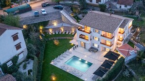 Une maison moderne à deux étages, dotée d’une piscine, d’un espace extérieur aménagé et d’un jardin bien entretenu.