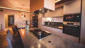 Une cuisine moderne dotée d’un îlot central, d’appareils électroménagers intégrés et d’un coin repas avec une longue table et des chaises.