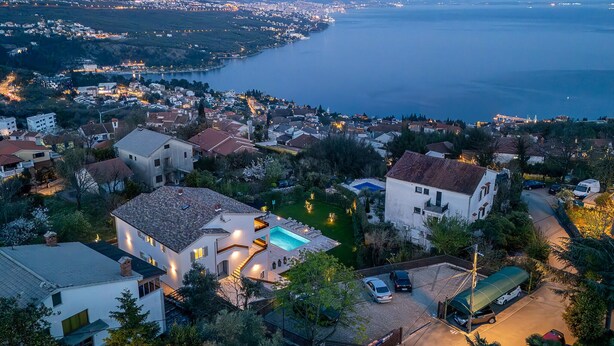 Un quartier r ésidentiel situé sur la côte, avec des maisons, une piscine et une vue sur la mer.