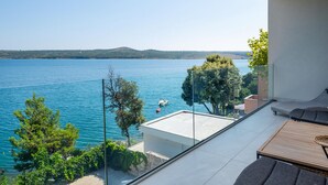 Varanda com vista desobstruída para um lago, um barco e colinas ao longe.