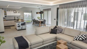A modern living room with a sofa, coffee table, and dining area. - Pet friendly home in Perini (Perini)
