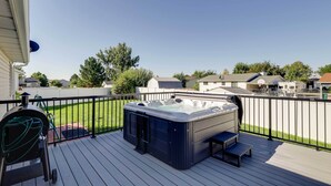 Una terrazza con idromassaggio, barbecue e panchina.