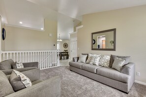 A living room with a grey sofa set, a patterned rug, and a large mirror on the wall. - Family-Friendly Clearfield Home w/ Hot Tub! (Clearfield)