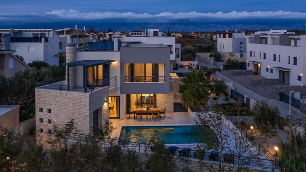 A modern two-story house with a swimming pool, surrounded by other residential buildings. - Beautiful home in Privlaka with sauna (Privlaka)
