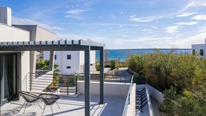 A modern outdoor terrace with a clear view of the sea, a covered seating area, and a staircase leading to an upper level. - Beautiful home in Privlaka with sauna (Privlaka)