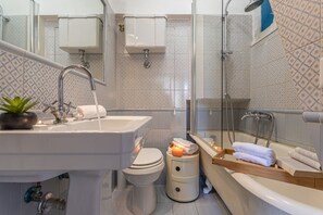 A modern bathroom with a sink, toilet, and shower area.