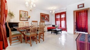 A spacious living room with a dining area, a sofa, a coffee table, and a fireplace.
