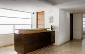 Ein Empfangsschalter mit Holzbeschlag und einem an der Wand montierten Rauchmelder.