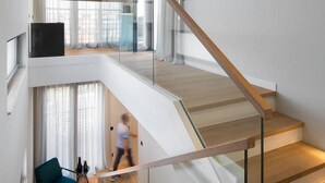 A modern interior with a staircase, a living area with a sofa and a coffee table, and a view through a glass partition. - Awesome home in Zadar (Zadar)
