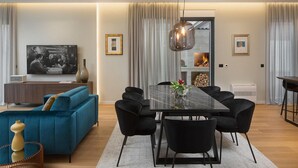 A modern living room with a blue sofa, black chairs, a glass-top dining table, and a fireplace. - Awesome home in Zadar (Zadar)