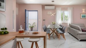 A modern kitchen with a dining area, a sofa, and a window with curtains. - Beautiful home in Nin (Nin)
