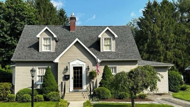 A two-story house with a front porch, a chimney, and a well-maintained lawn. - Charming 3 bedroom home  (Lewisburg)