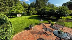 A patio area with a brick floor, metal chairs, and a round table. - Charming 3 bedroom home  (Lewisburg)