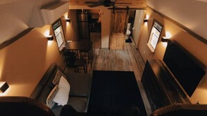 A compact, cozy interior with a dining area, a sofa, and a TV.