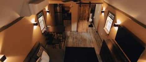 A compact, cozy interior with a dining area, a sofa, and a TV.