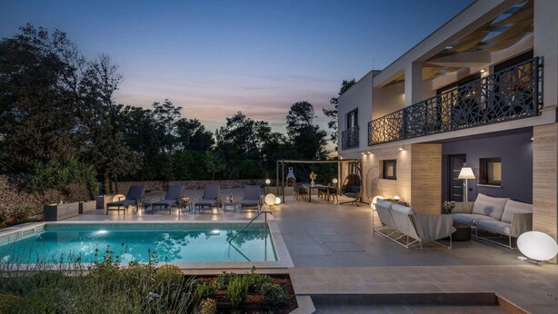 A modern outdoor pool area with lounge chairs and a dining setup.