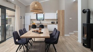 Een moderne keuken met witte kasten, een houten eettafel en zwarte stoelen.