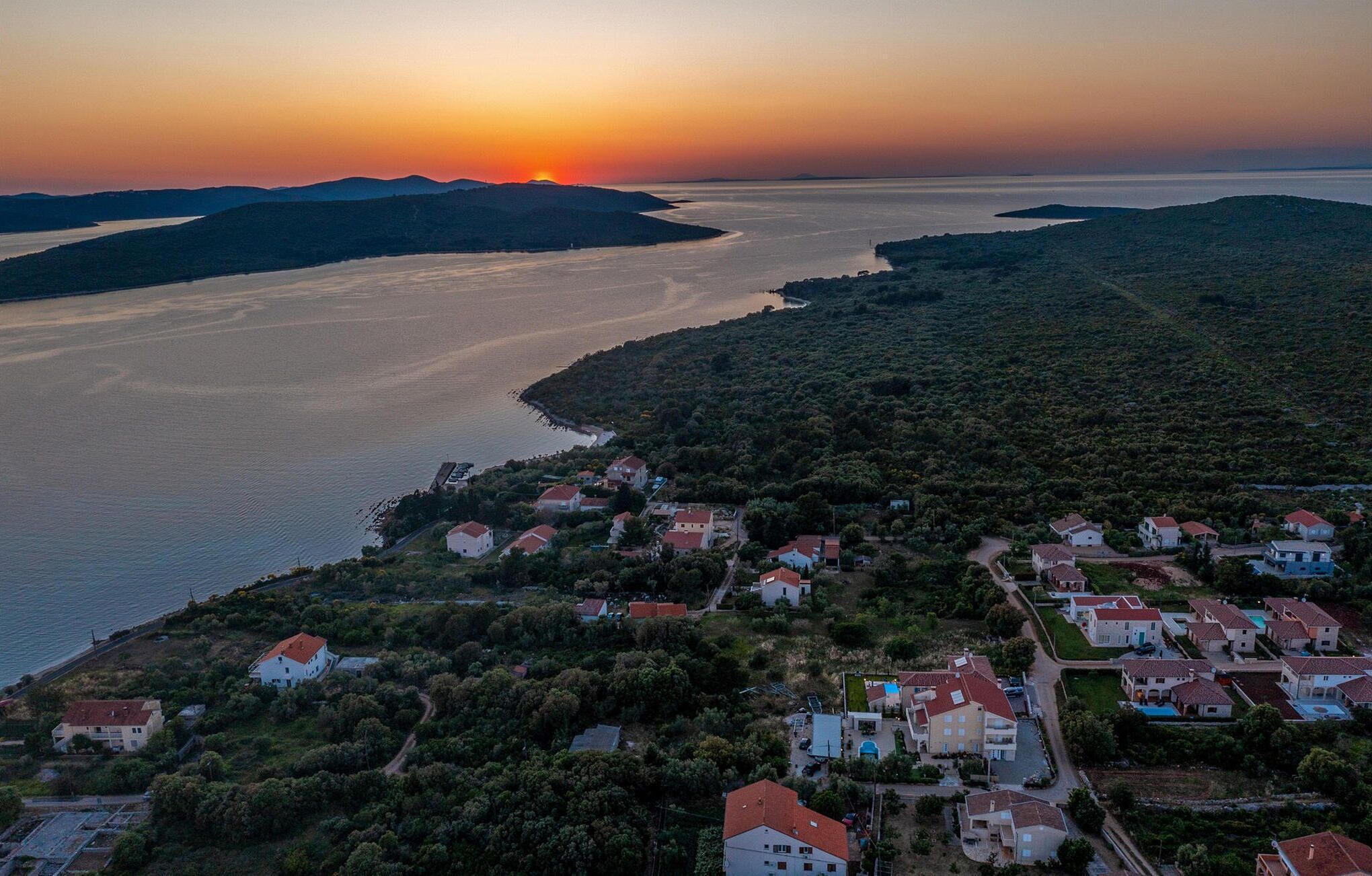 Un pueblo costero con casas y vistas al mar al atardecer.