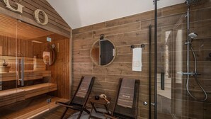 Una sala de sauna con paredes de madera, una puerta de vidrio y dos bancos de madera.