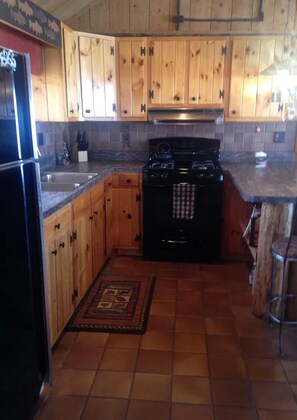 Effortlessly prepare meals in this well-equipped kitchen with a black stove, stainless steel sink, and ample countertop space.