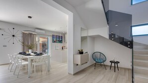 A modern interior with a dining area, a staircase, and a view of the outside. - Beautiful home in Sukosan with WiFi (Sukosan)