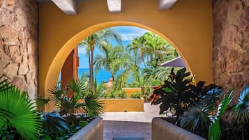 Une entrée en arc offrant une vue sur la mer et sur une végétation tropicale.