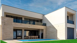 A modern two-story house with a swimming pool, large windows, and a flat roof. - Cozy home in Nin with house sea view (Nin)
