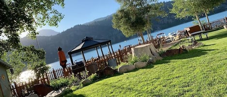 A gazebo with a view of a lake and mountains in the background.