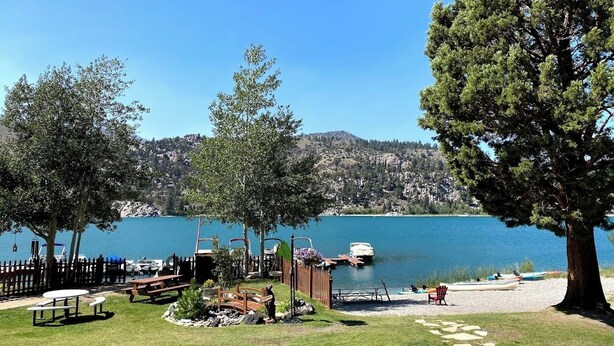 A lakeside park with picnic tables, a wooden deck, and a boat dock. - Big Rock Resort (June Lake)