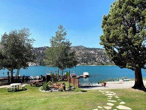 A lakeside park with picnic tables, a wooden deck, and a boat dock. - Big Rock Resort (June Lake)