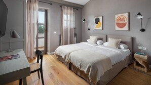 A bedroom with a bed, a desk, a chair, and a window with curtains.