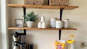 Eine Küche mit Holzböden, einer Kaffeemaschine, einer frischen Popcornbox und einem Wasserkocher.