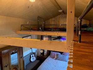 A bunk bed room with a wooden ceiling, a ceiling fan, and a guitar on the lower bunk. - The Wild West's Best Kept Secret  (Hurricane)