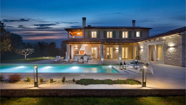 A two-story house with a swimming pool, outdoor seating, and a stone wall. - Lovely home in Karojba with sauna (Karojba)